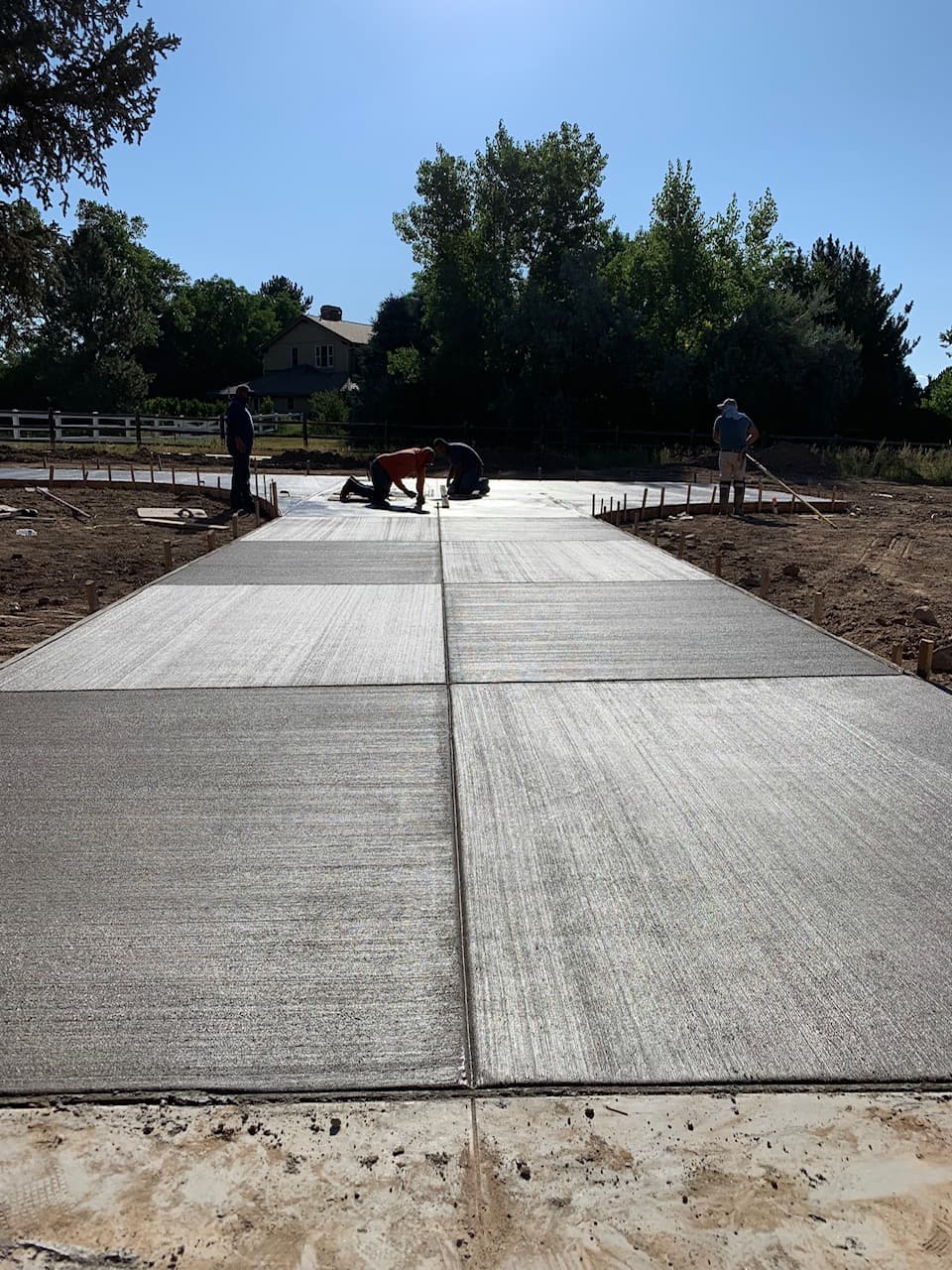 Crew completing the surface finish during active placement.